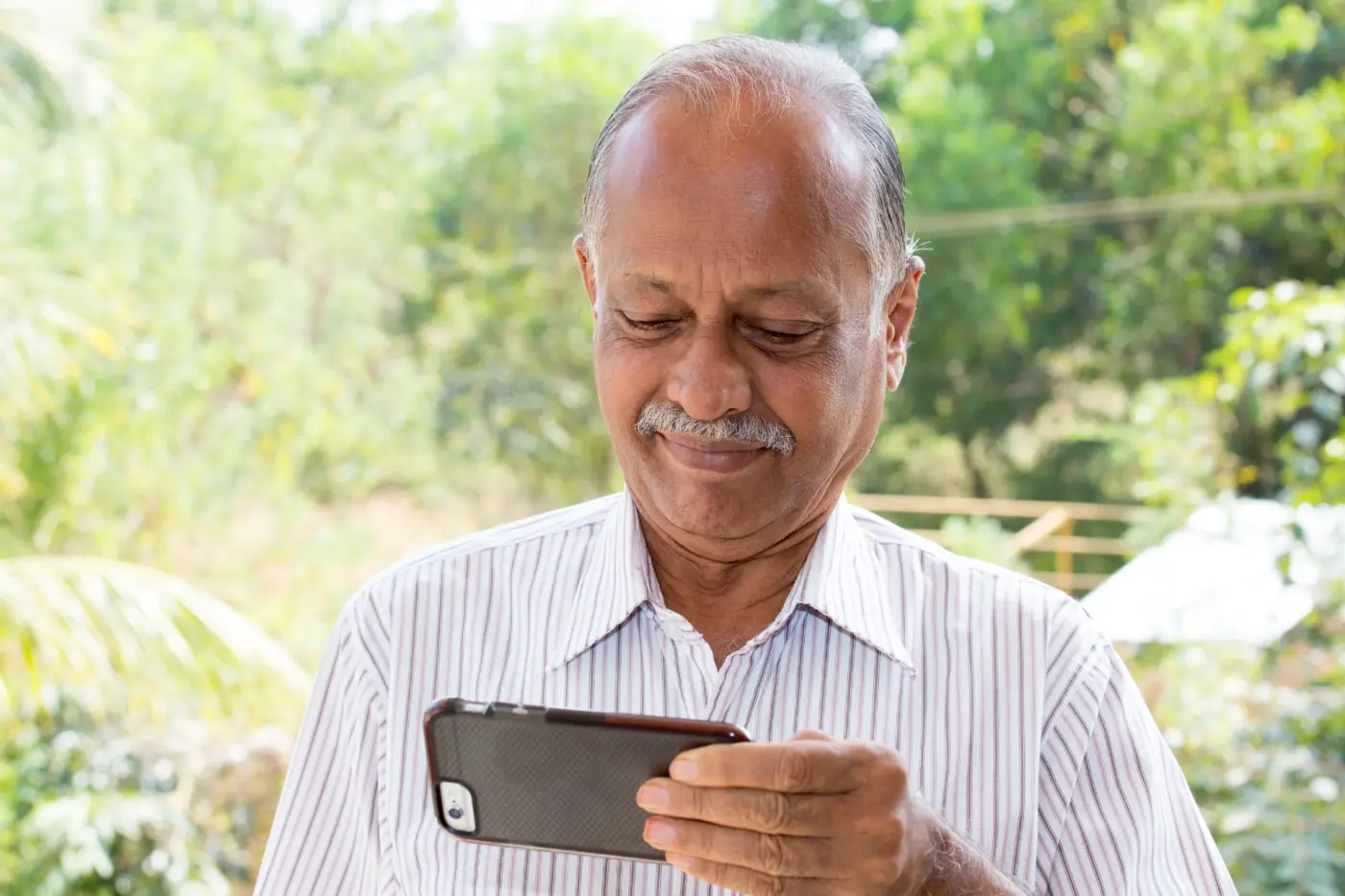 A volunteer helping an elderly woman use her phone safely